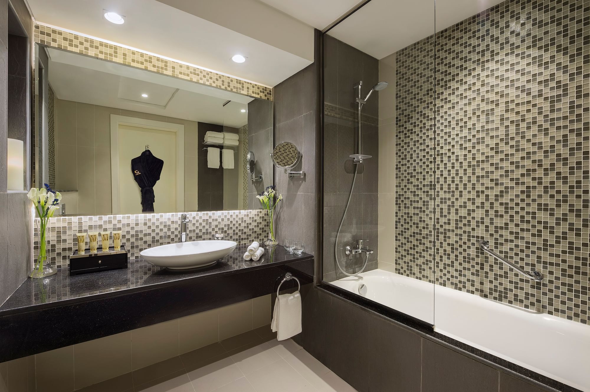 Bathroom vanity, bathtub with bathrobes in Three Bedroom Suite at DAMAC Maison Distinction