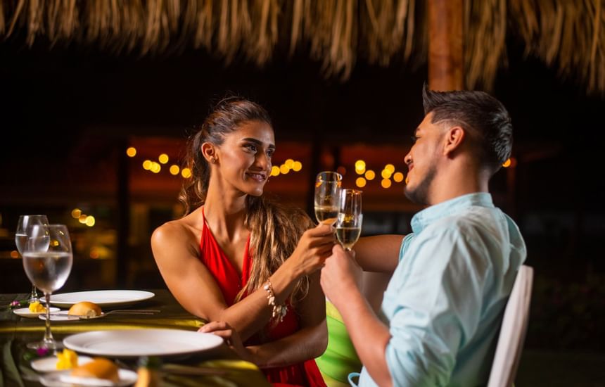 Una pareja brindando cócteles en el restaurante de Fiesta Resort