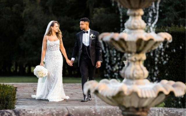 Bride and groom by the Easthampstead Park fountain at their summer wedding