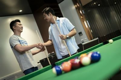 two guys shaking hands before pool game