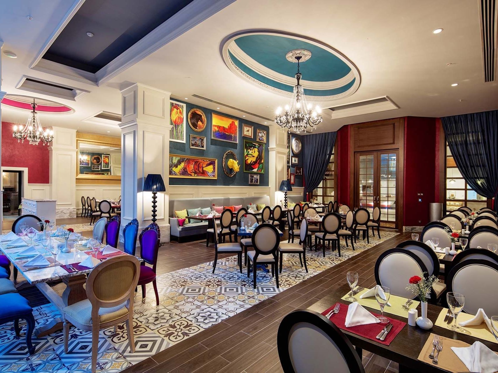 Dining room with art, patterned floor and chandeliers in a restaurant at Titanic Deluxe Golf Belek
