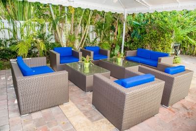 Patio lounge area arranged by a lush green lawn at Ocean Lodge Boca Raton