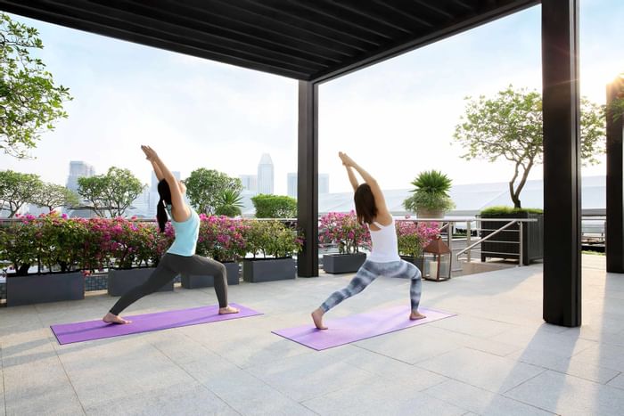 Two ladies engaging in yoga exercises at Fullerton Group