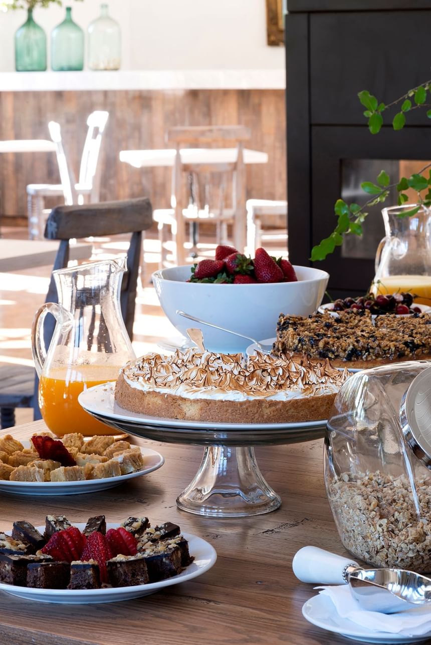 Breakfast buffet with cakes & juices on a wooden table in Ensamblaje Restaurant at NOI Blend Colchagua 