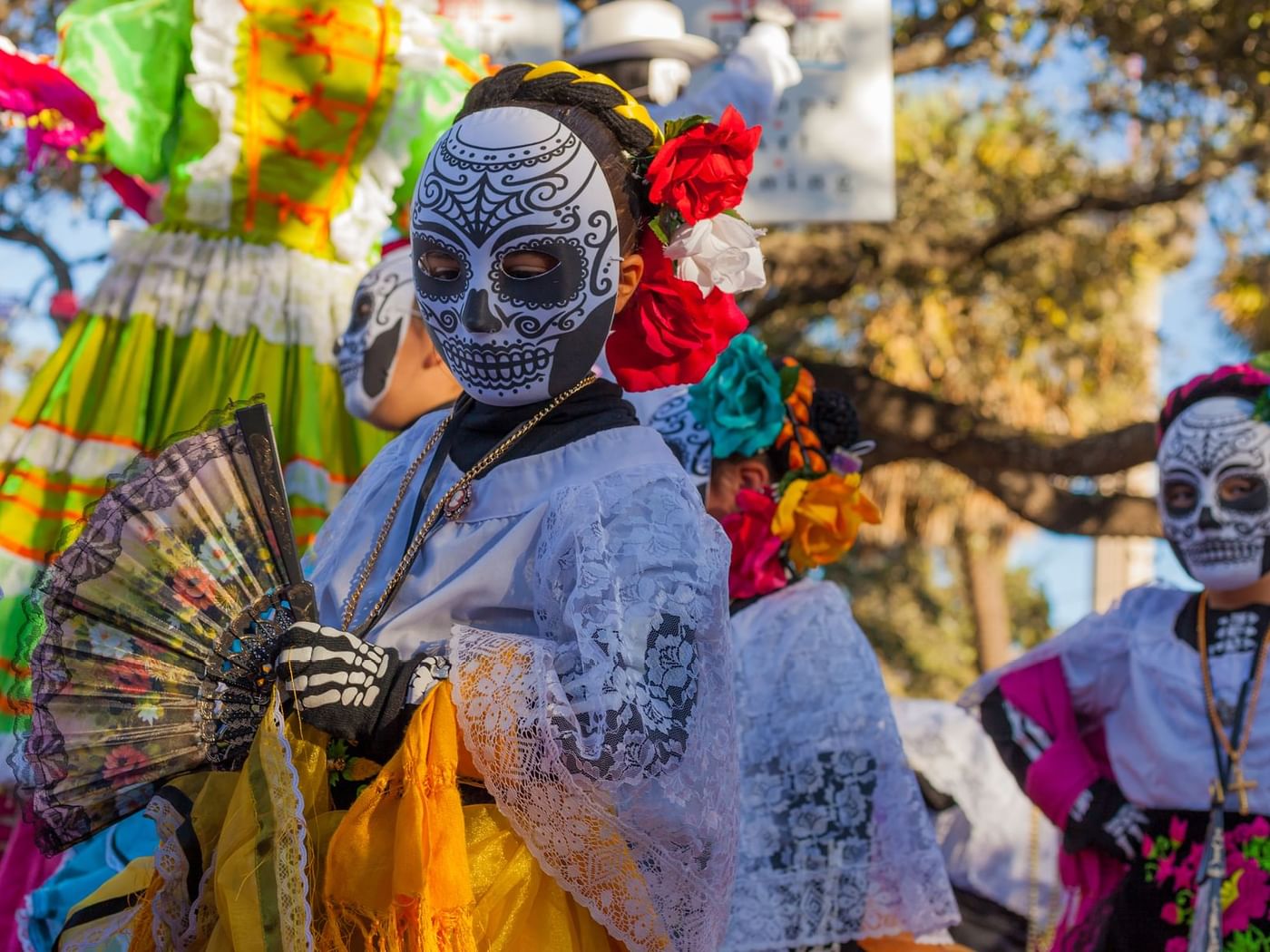 People in colorful costumes celebrate the day of the dead near Grand Fiesta Americana