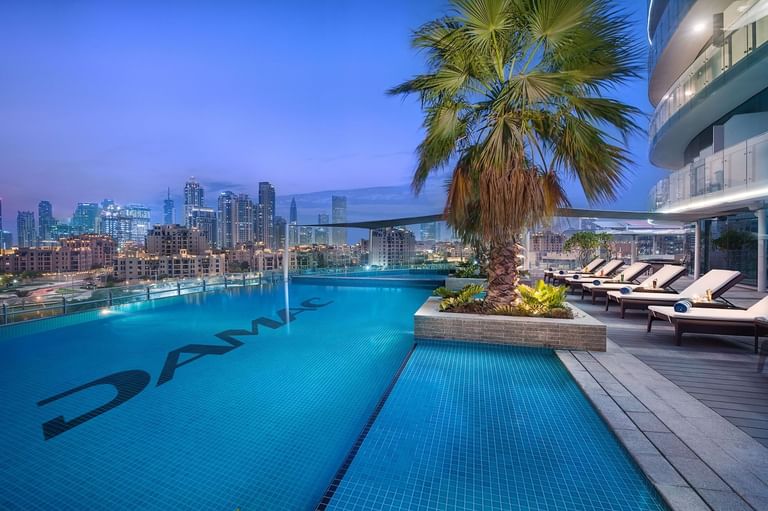 Swimming Pool with sun loungers at DAMAC Maison Distinction Hotel in Dubai