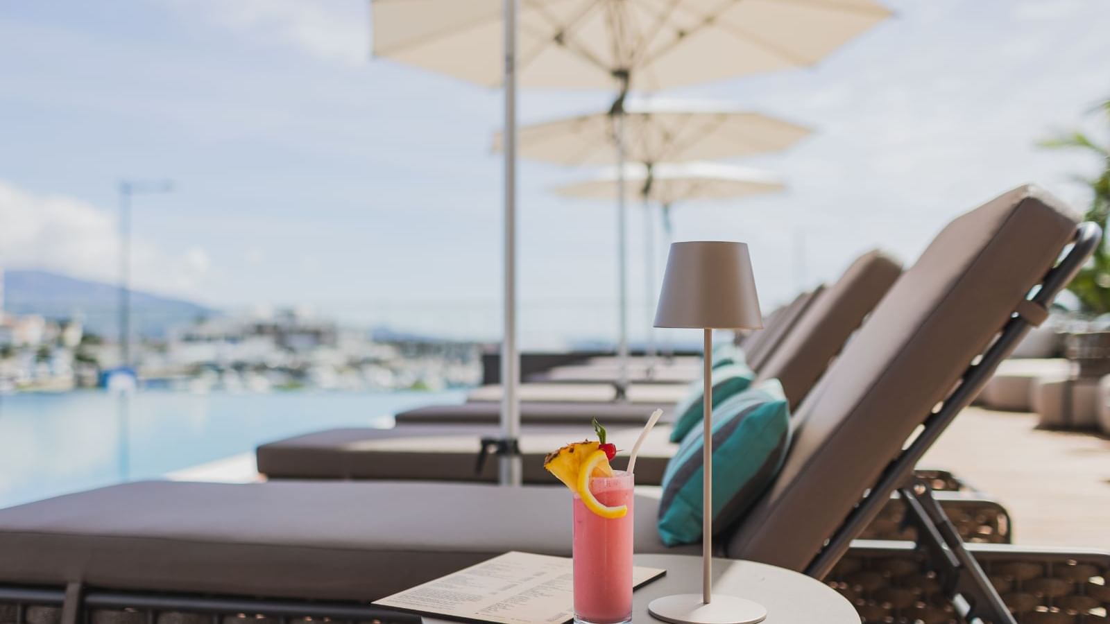 Close-up of cocktail on table by a lounger in Palhabote Bar at Hotel Marina Atlântico