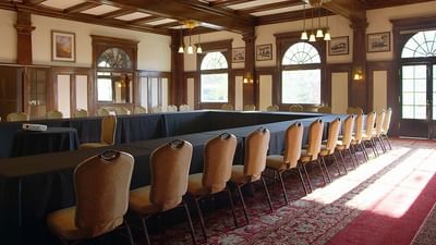 Spacious meeting room with long table and multiple chairs arranged for a meeting at The Stanley Hotel