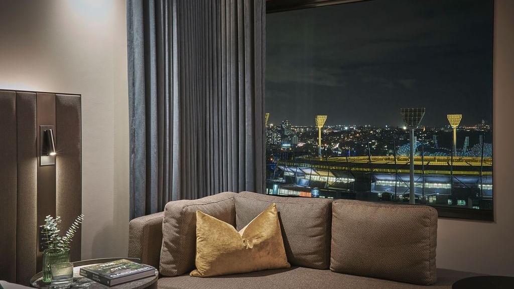 Deluxe Executive Room with sofa, nighttime city views, and modern decor at Pullman East Melbourne