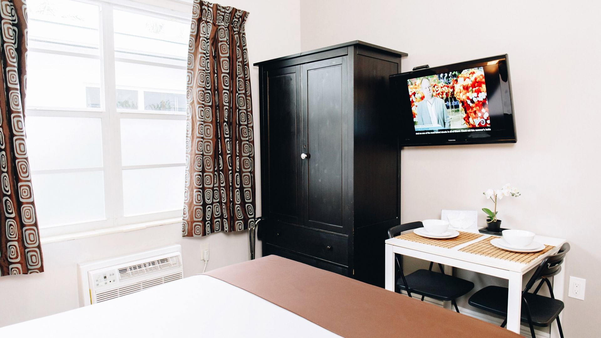 Queen studio with a king bed, TV & dining at DOT Hotels