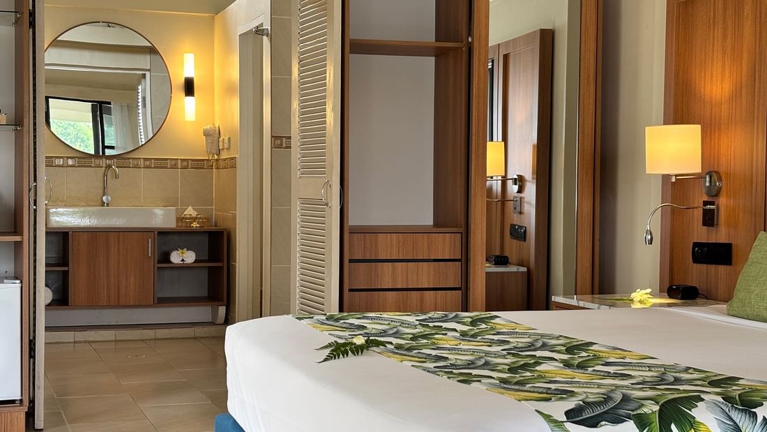 Bedroom with tropical decor and wooden furniture at Warwick Le Lagon - Vanuatu, Efate.