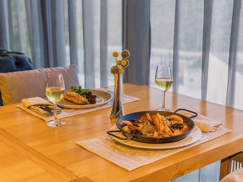 Variety of dishes served with wine on a dining table in Restaurante Azur at Live Aqua Resorts and Residence Club