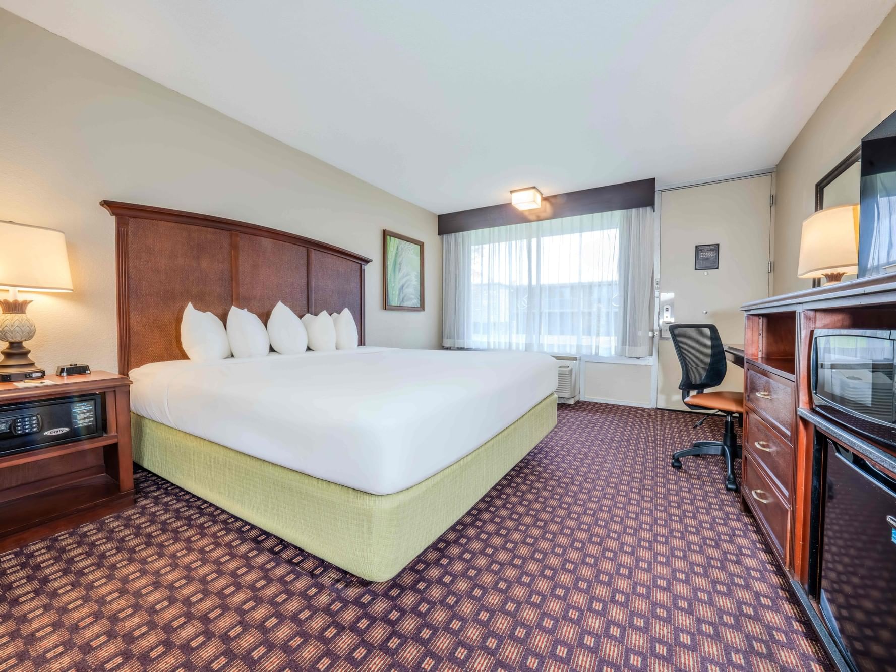 Bed & lounger in Deluxe King Room at Rosen Inn International