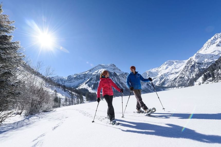 A couple snowshoeing in Tannheimer Valley at Liebes Rot Flueh