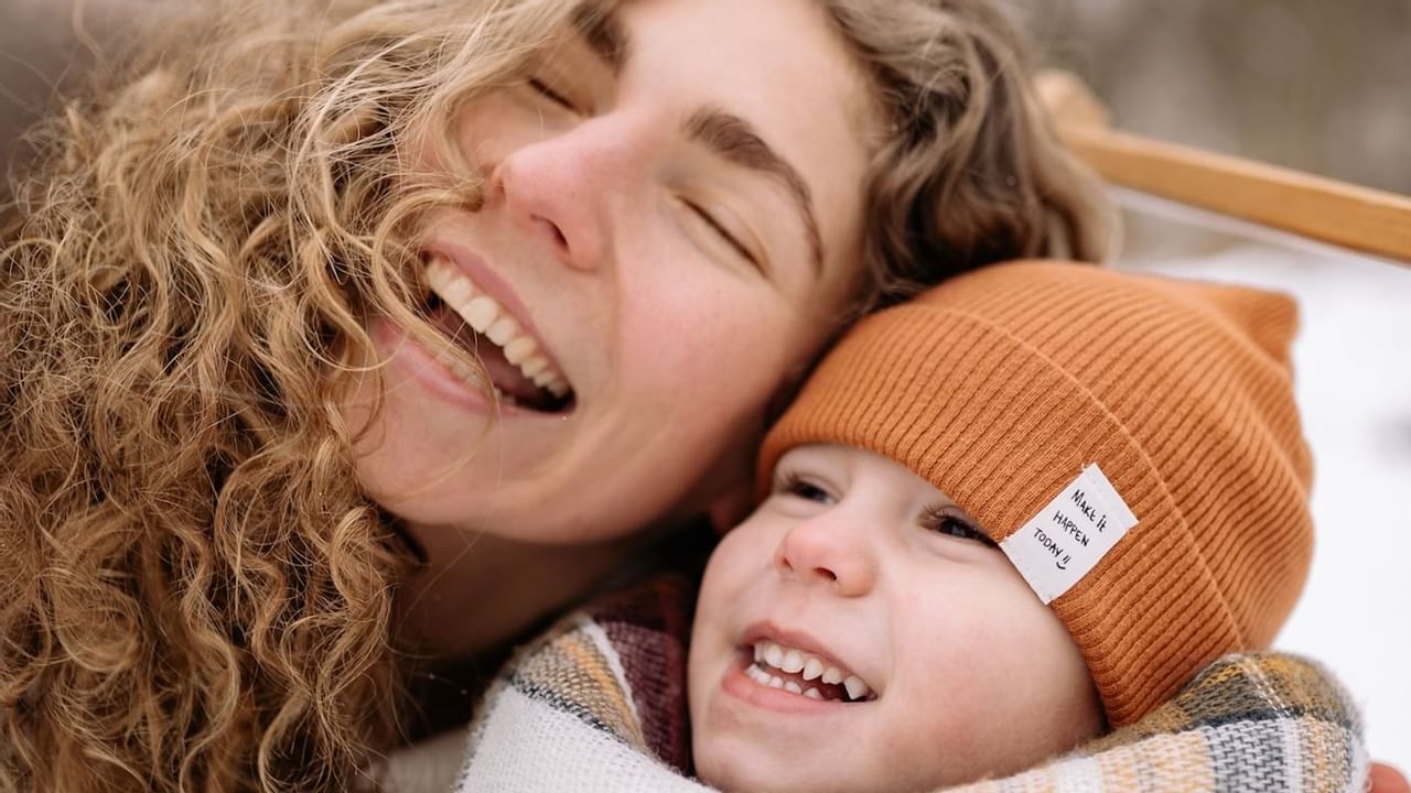 A woman and child smiling in winter setting