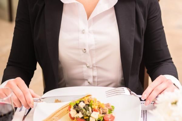 Women tucking into her meal during a business lunch meeting