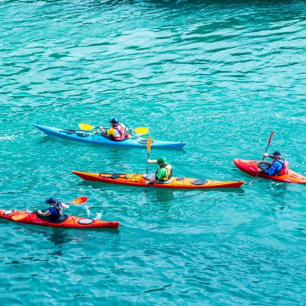 Four people kayaking on a river near Falkensteiner Hotel Schladming