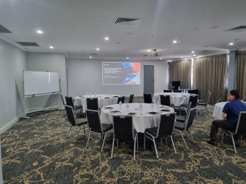 Banquet-style tables set up with projector & whiteboard in Pandora Room in Hotel Grand Chancellor Townsville