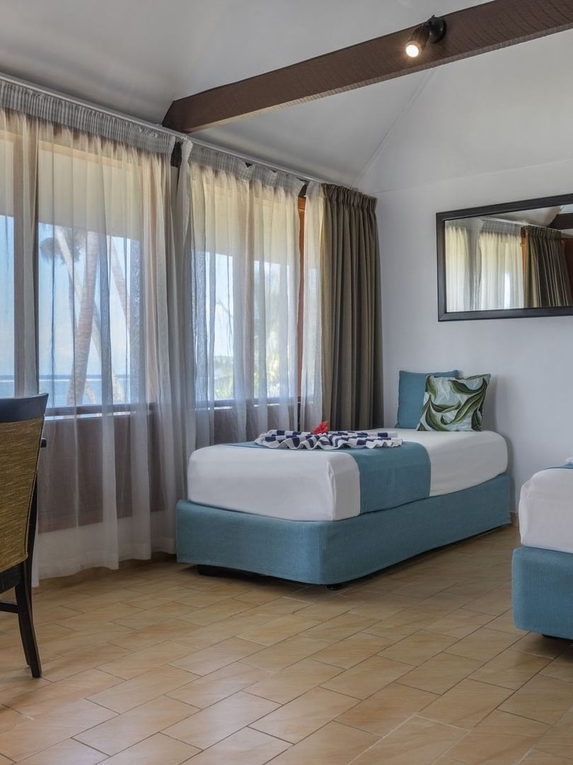 Two beds and chair in Beach Front Bure at Tambua Sands Beach Resort in Sigatoka
