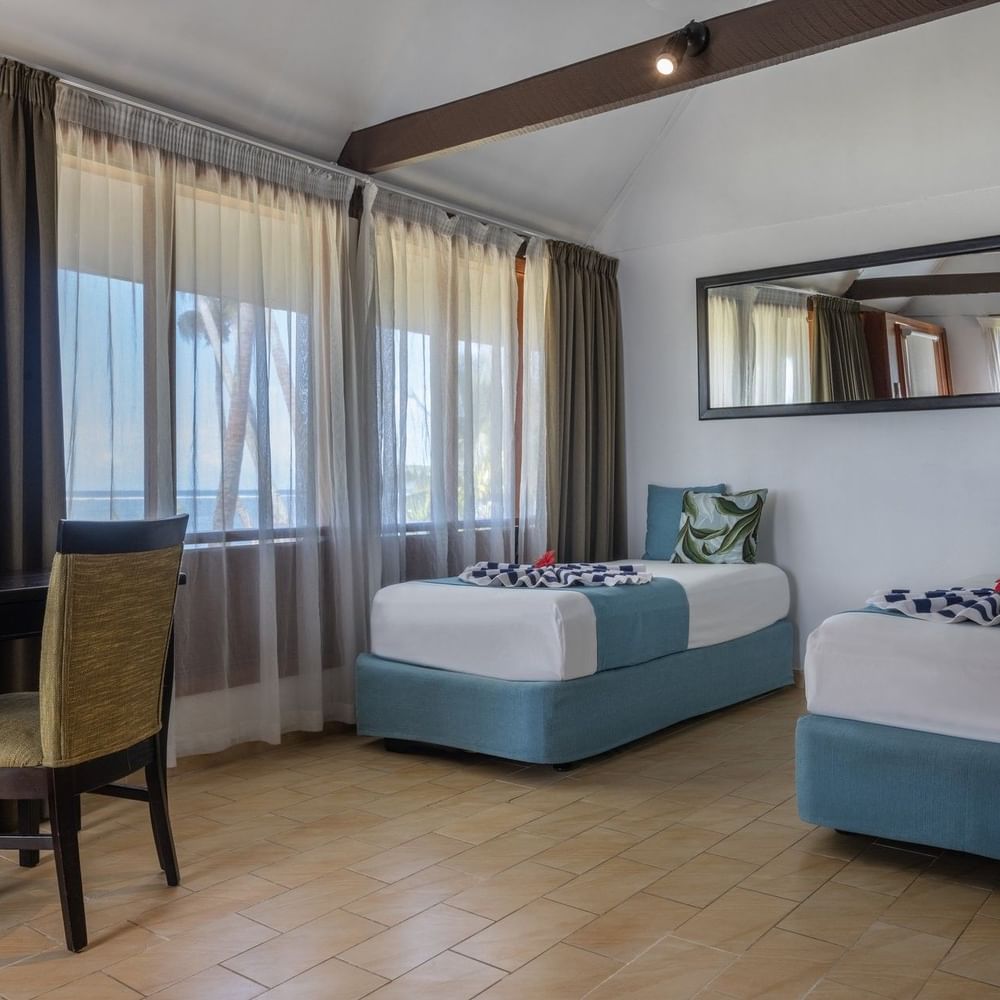 Two beds and chair in Beach Front Bure at Tambua Sands Beach Resort in Sigatoka.