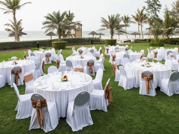 Banquet rounds set up on Laguna lawn at Ajman Hotel
