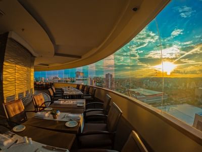 Área de mesa de comedor con vista a la ciudad en El Giratorio del Hotel Dann Carlton Barranquilla