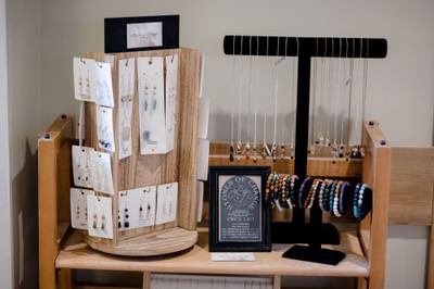 Handmade gemstone necklaces and colorful beaded bracelets on wooden display stands at La Tourelle Hotel and Spa