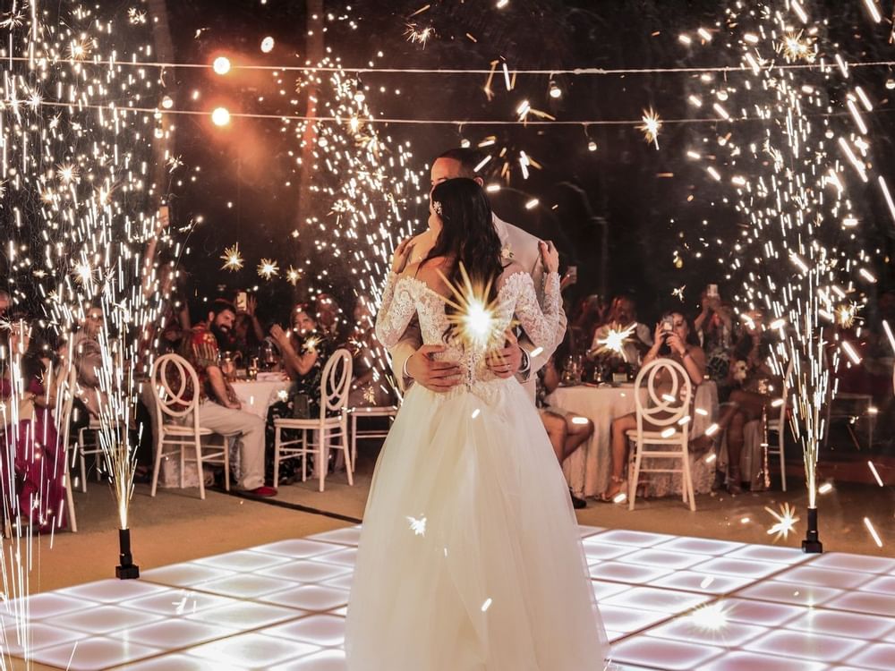 Bride & groom dancing with fireworks in background at FA Hotels