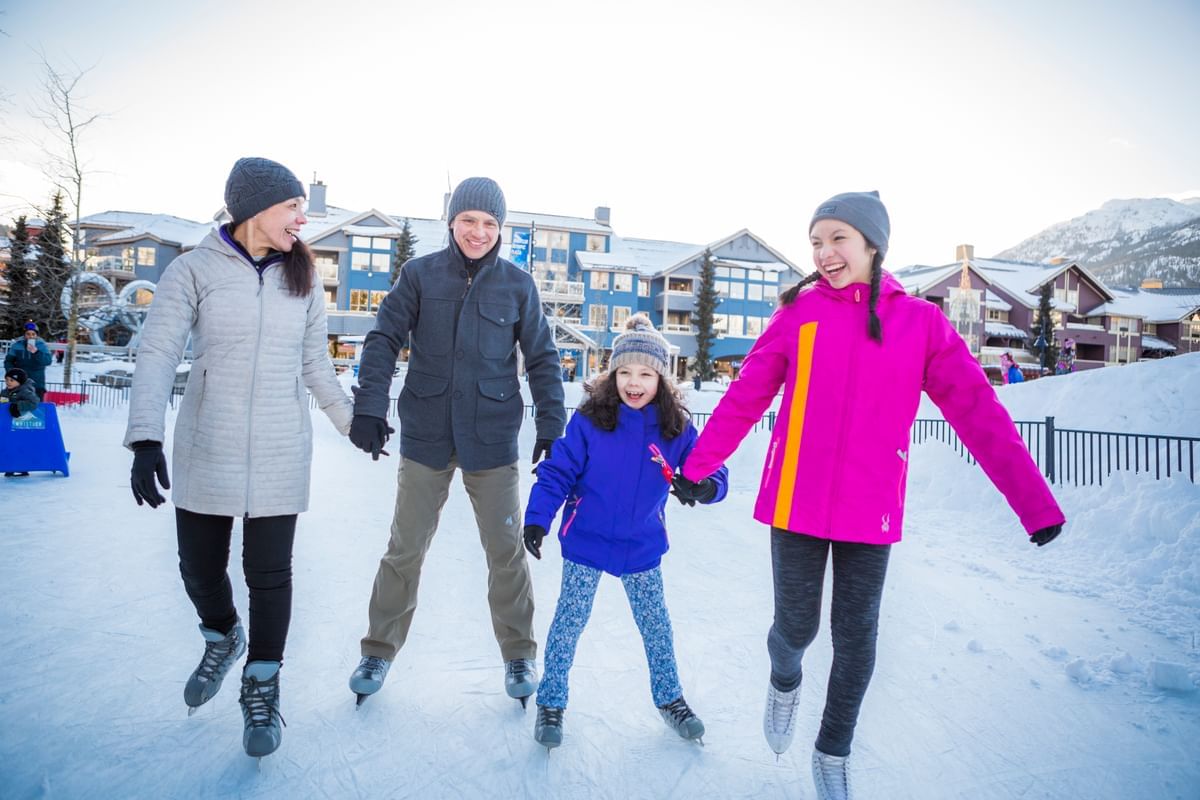 Family skiing on a snow slope near Blackcomb Springs Suites