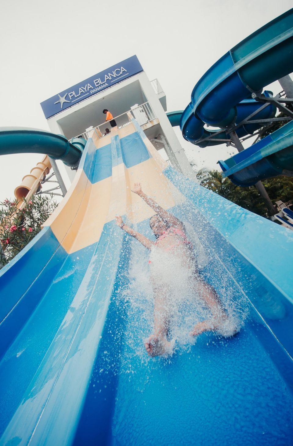 Girl sliding on a slide splashing water at Playa Blanca Beach Resort