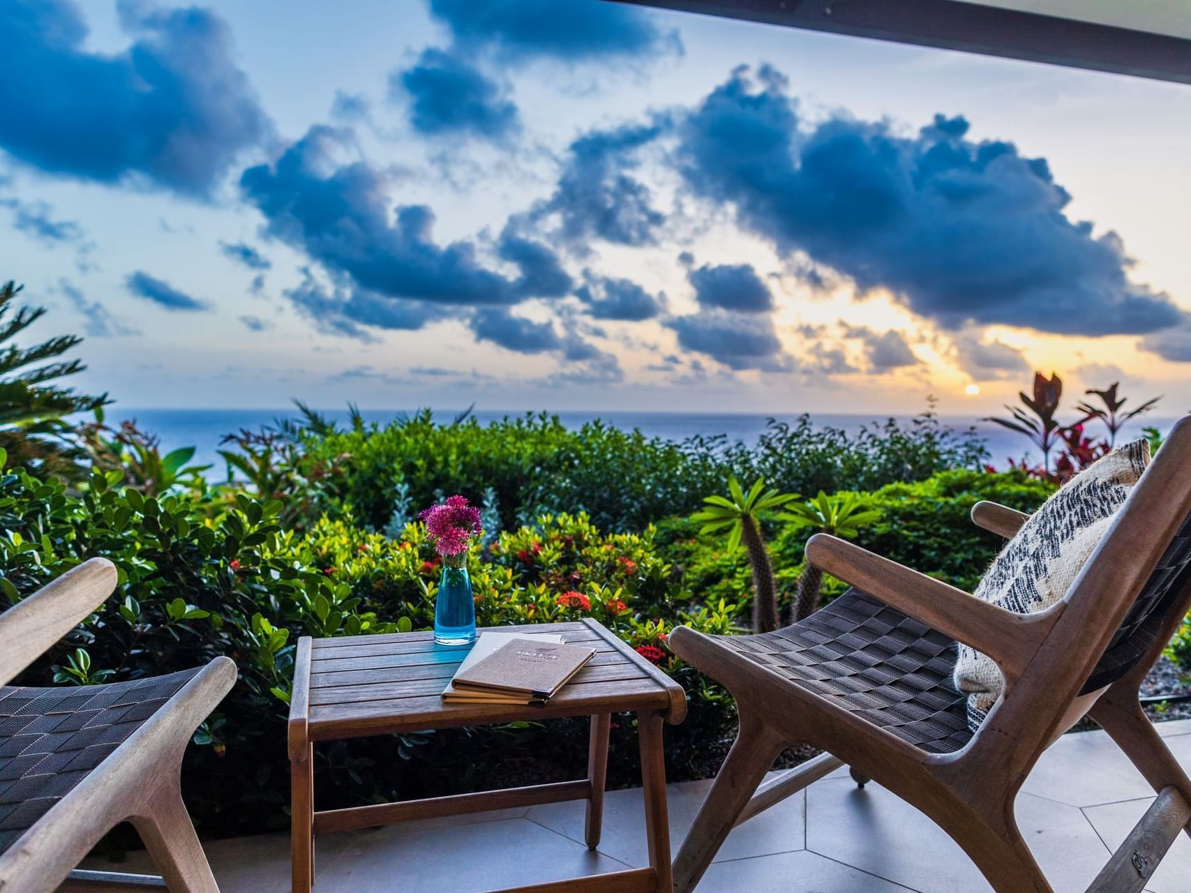 Wooden chairs and flowers set for sunset views at Breeze Restaurant in Golden Rock Resort