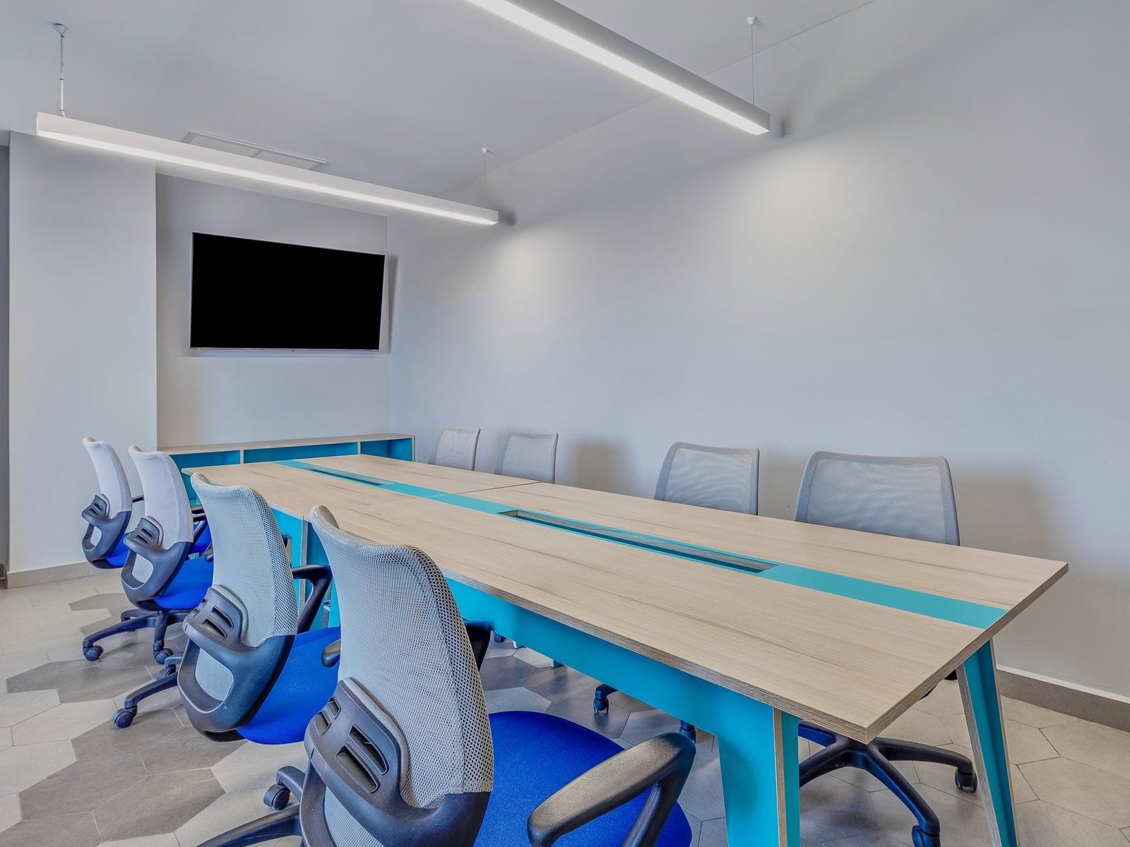 Wall TV & a wooden meeting table in a meeting room, One Hotels