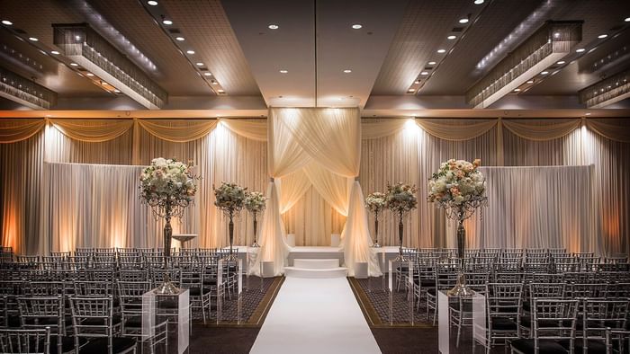 Wedding ceremony setup with chairs, floral arrangements, and a stage in the Hotel Arista in Naperville, Illinois.