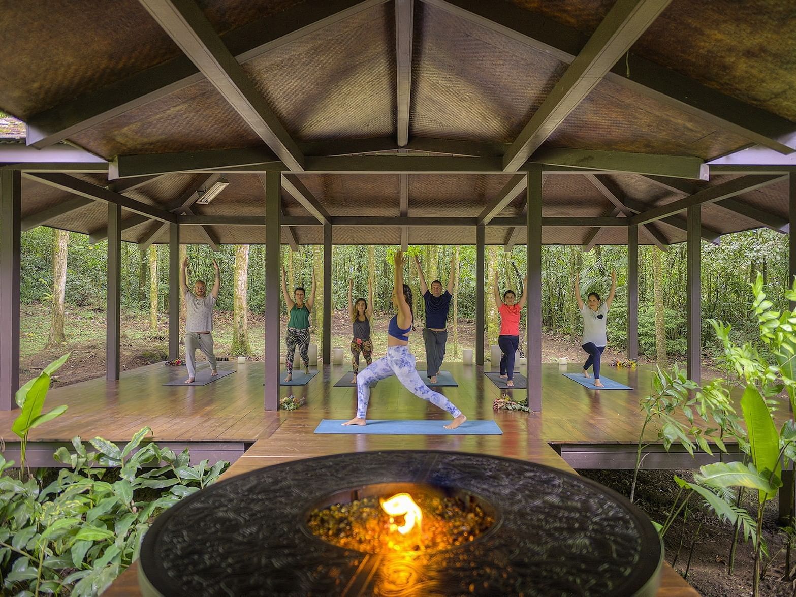 group of people practicing yoga in outdoor studio