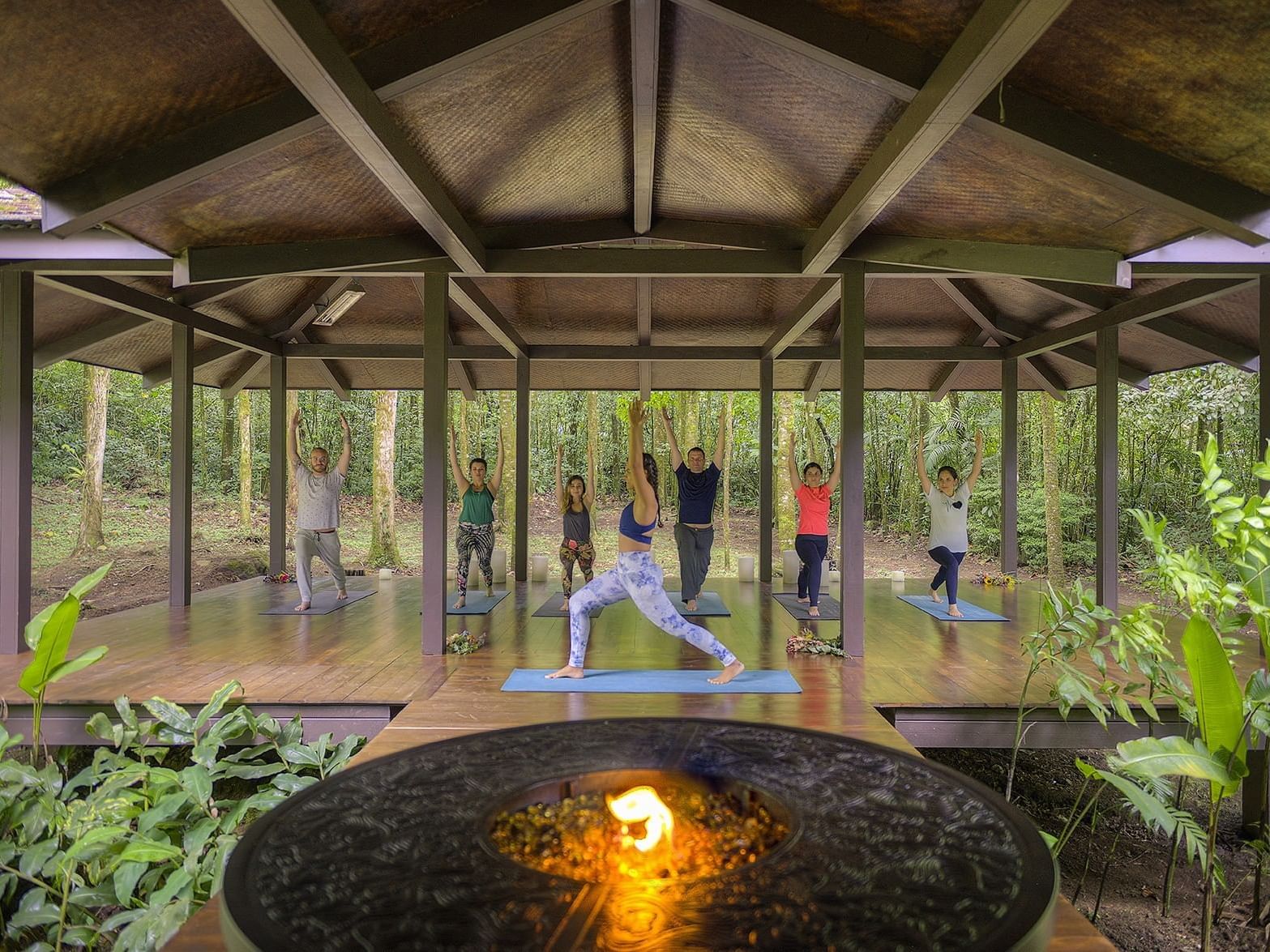 grupo practicando yoga en estudio al aire libre