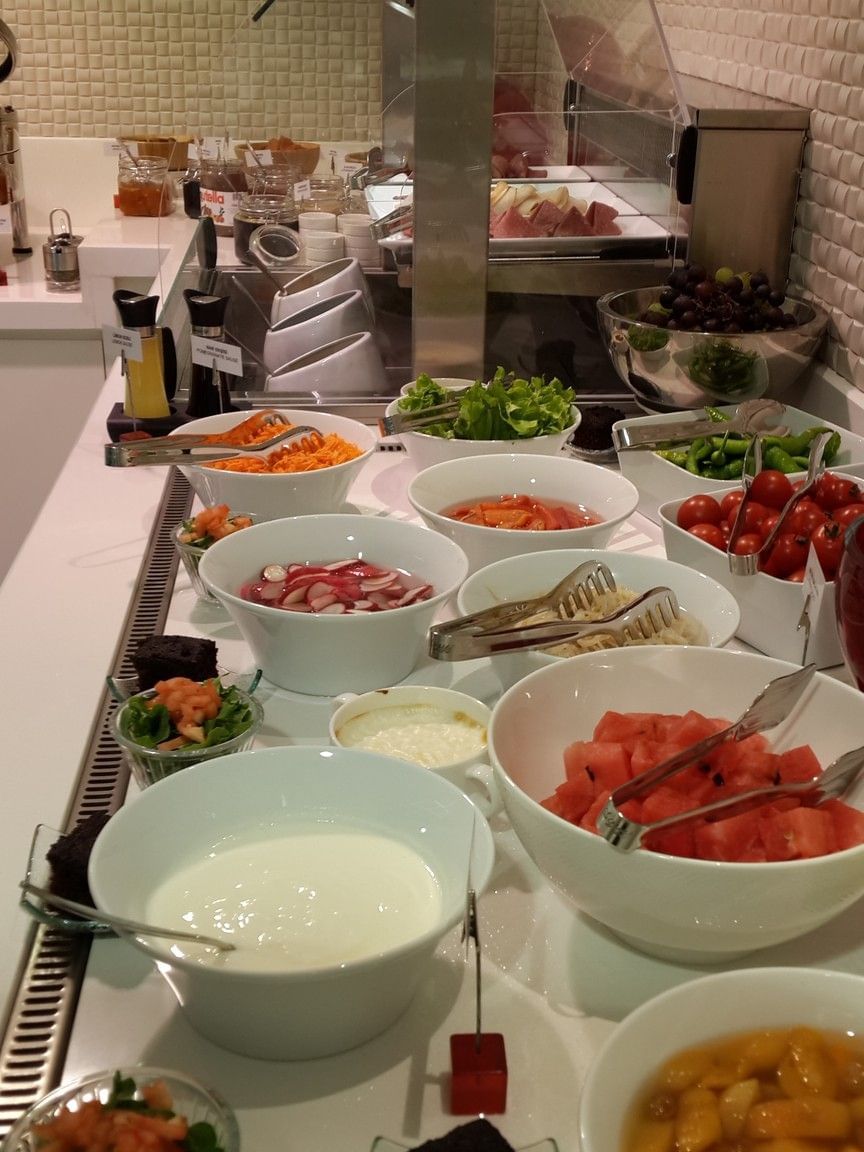 Fresh watermelon by bowls of radish and tomatoes under a bright light in Breakfast & In-Room Dining at Warwick Ankara