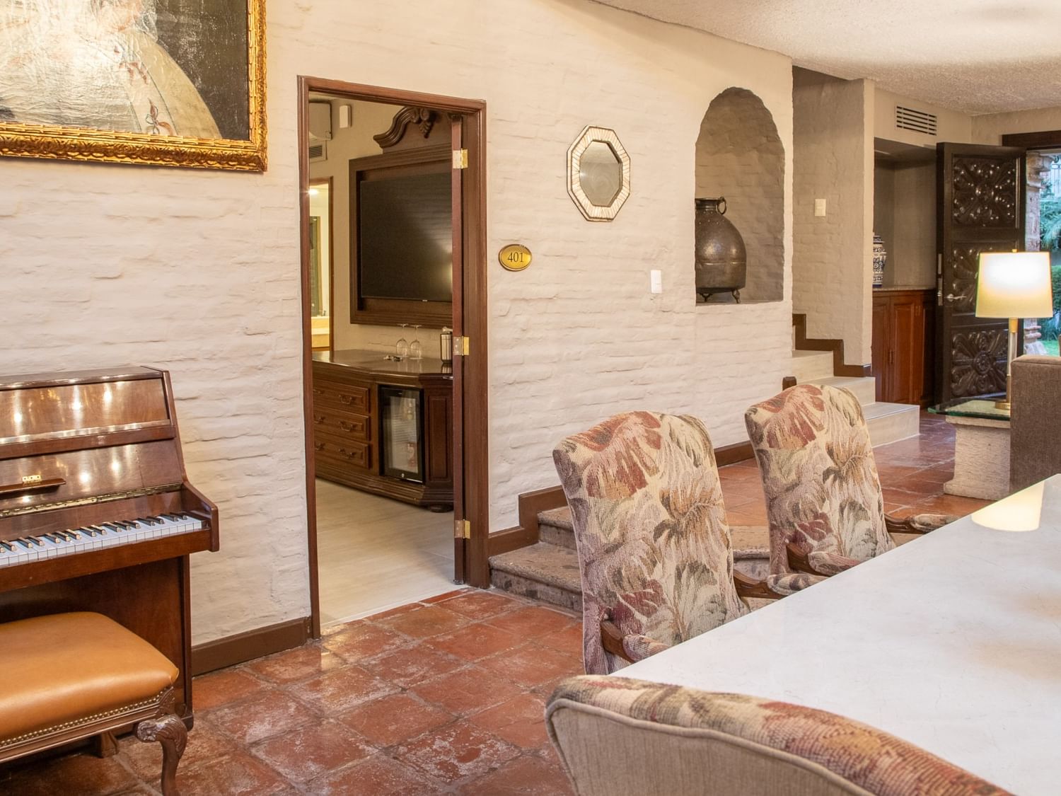 Suite Presidencial King con piano, paredes de ladrillo blanco y área de estar en Quinta Real Guadalajara