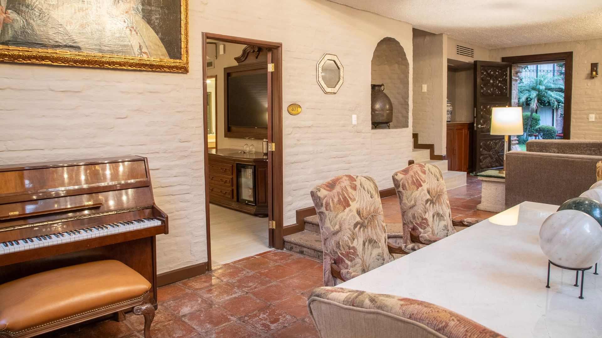 Suite Presidencial King con piano, paredes de ladrillo blanco y área de estar en Quinta Real Guadalajara