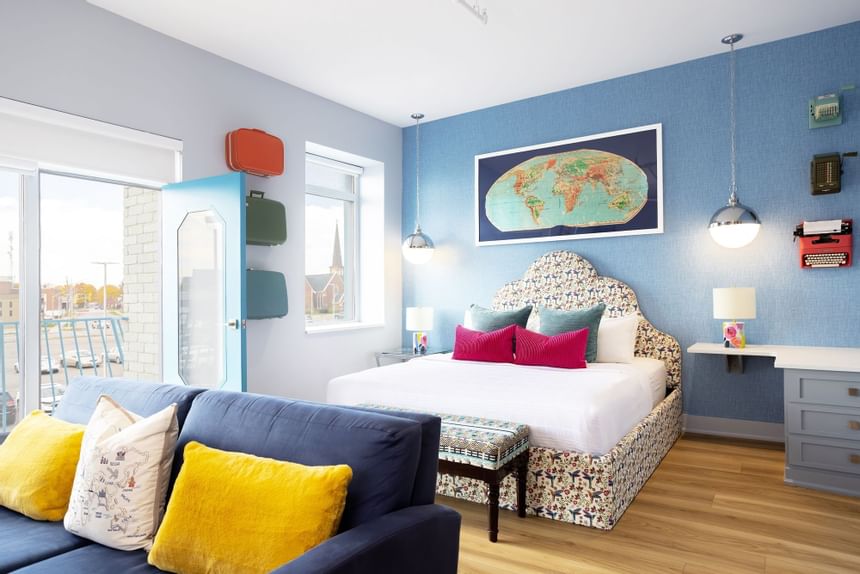 King bed, cozy sofa, nightstand with side cupboard in King Premiere at Retro Suites Hotel