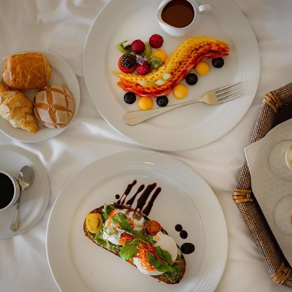 Elegant in-Suite dining experience at Marquis Los Cabos Resort with a breakfast spread including fruit pastries and toast