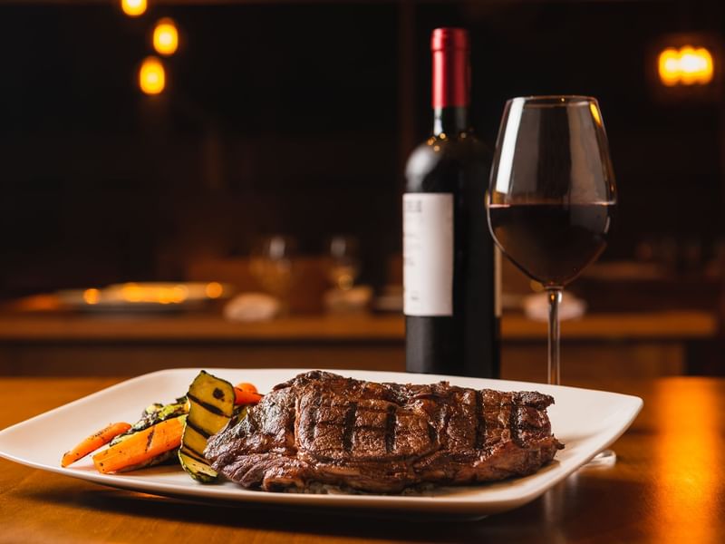 Steak dish served with wine at FA Hotels & Resorts