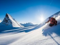 A man skiing on a mountain near Clique Hotels & Resorts