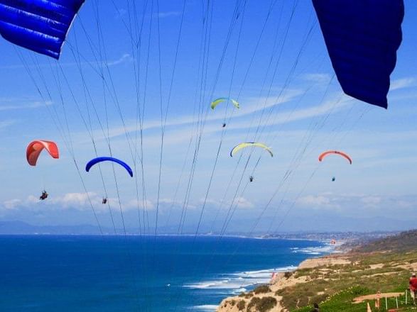 People paragliding above Sea near Inn by the Sea at La Jolla