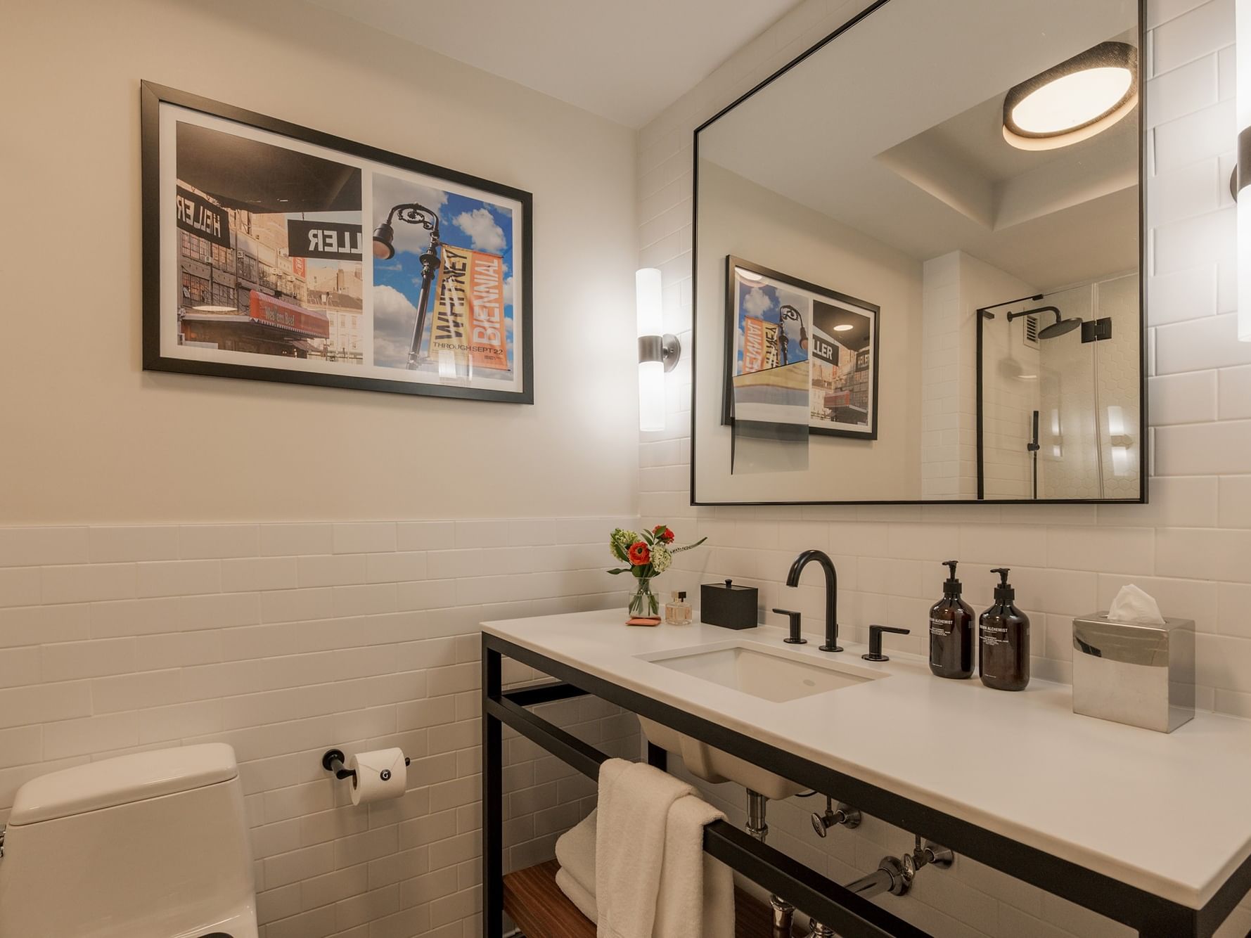 Bathroom with white tile, modern sink, and black faucet in Gansevoort Suite at Gansevoort Meatpacking NYC New York.