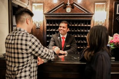 Male receptionist giving a key to the guest at The Eliot Hotel
