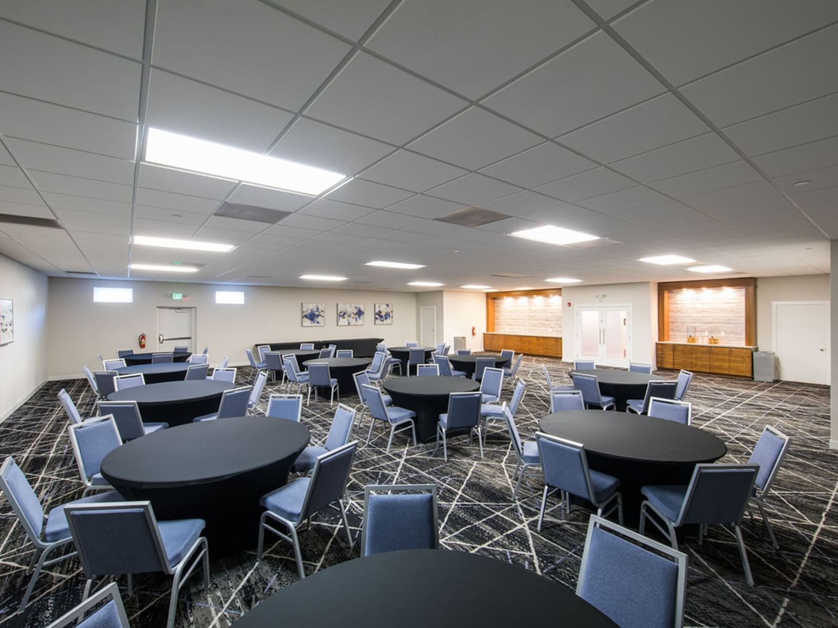 Blue & black table set-up in Pacific Banquet Room with carpeted floors at SeaCrest Oceanfront Hotel Pismo Beach