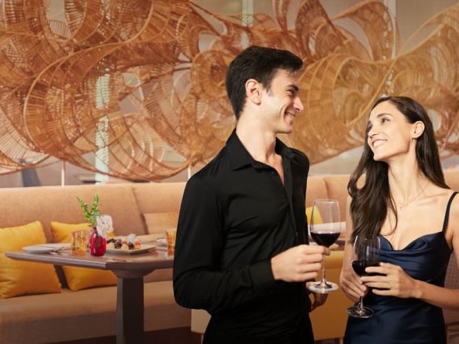 A couple standing in a restaurant, engaged in conversation and enjoying their dining experience.