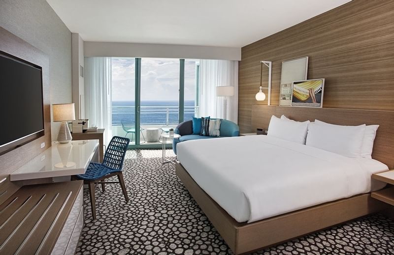 Deluxe King Oceanfront Balcony room featuring a king bed, a desk with a TV, seating area at The Diplomat Resort