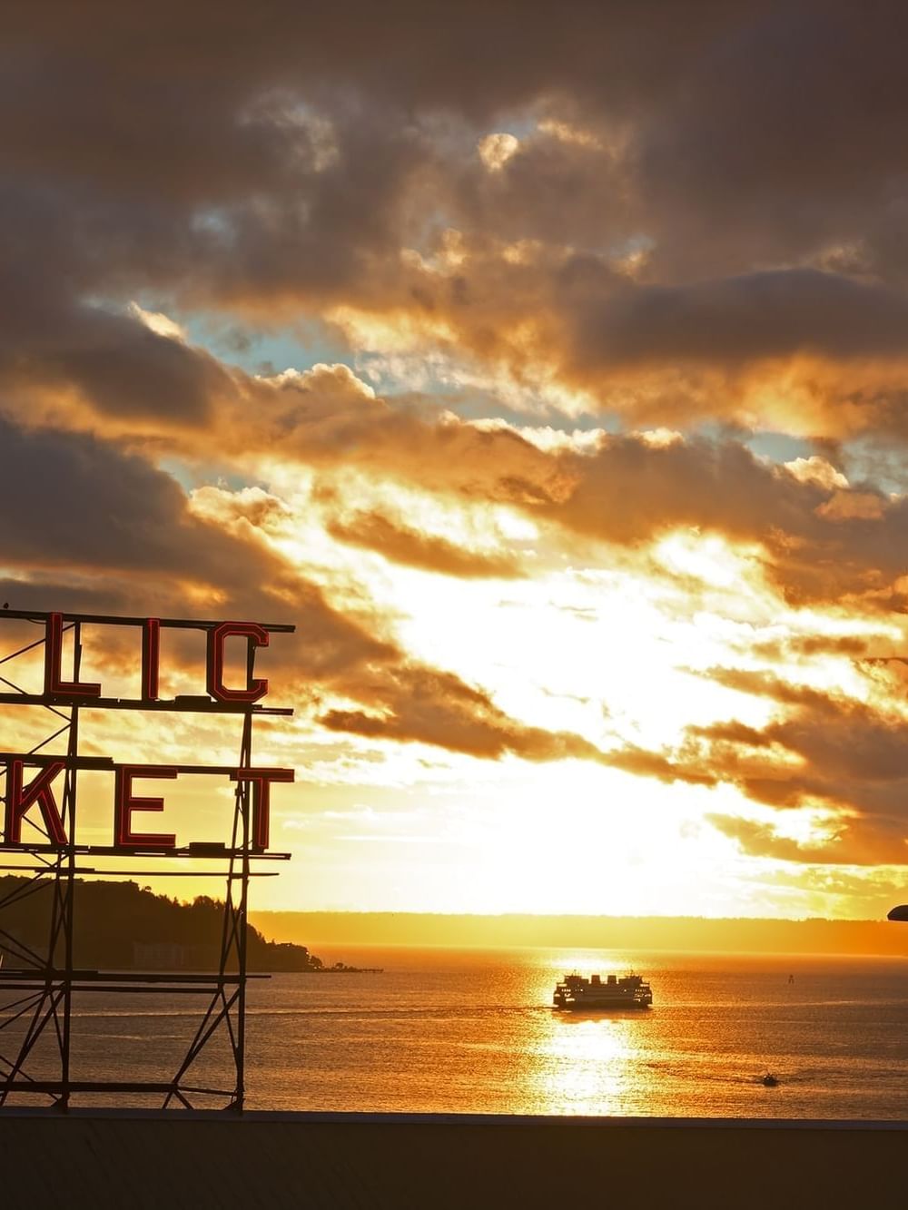 Public Market by a boat on the water under a dramatic cloudy sunset near Warwick Seattle