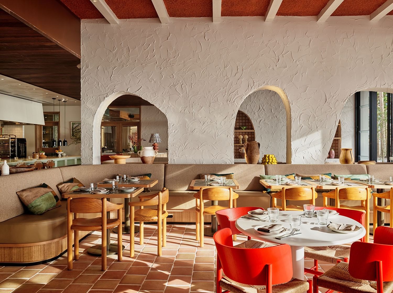 Elysium Hotels dining room with red chairs by wood tables under arched walls, a top-choice hotel in Neutral Bay, Sydney